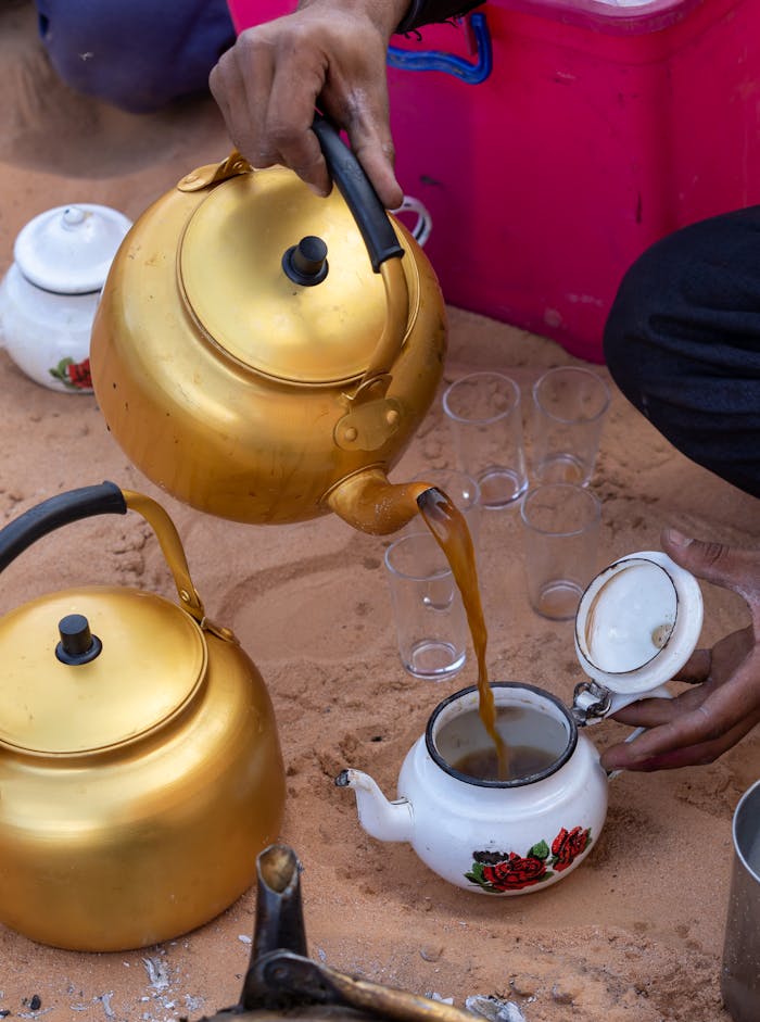 A captivating scene of traditional tea pouring in the Algerian desert, showcasing cultural richness.