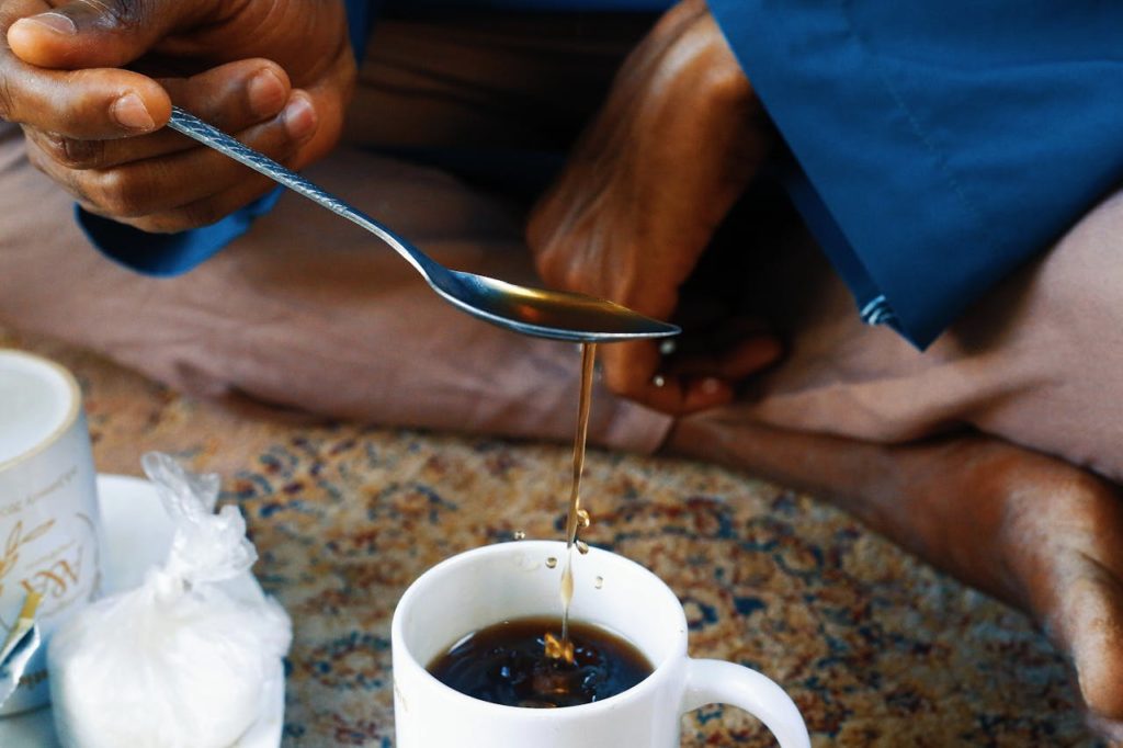 Close-up of a traditional tea pouring ritual in Abuja, Nigeria, showcasing cultural practices.