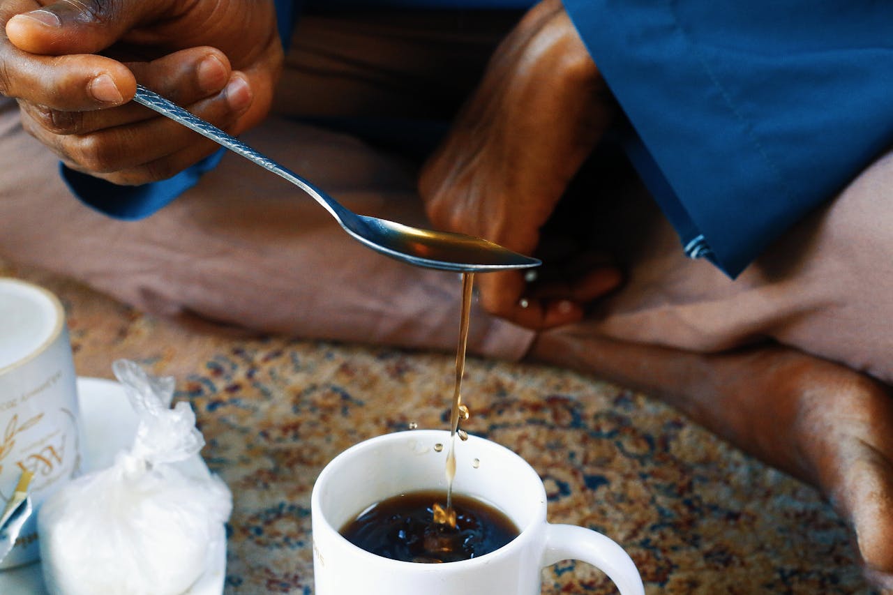 Close-up of a traditional tea pouring ritual in Abuja, Nigeria, showcasing cultural practices.